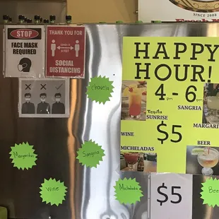 a happy hour sign on a refrigerator