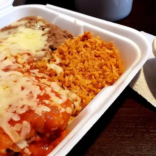 Burrito enchilada style; ranchero sauce; beans; rice.   Soup.   Take out packaging.