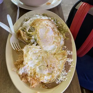 Green Chilaquiles with eggs, rice and beans, a breakfast plate.