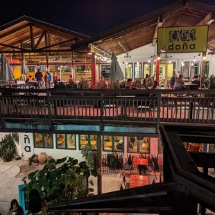 Outside. Dona is located in a two-story building with a cool outdoor deck. Restrooms are located upstairs (code required).