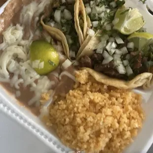 3lengua tacos fully dressed with beans and rice with 3 limes 2 salsas