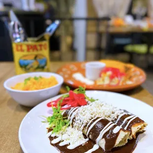 Enchiladas de Mole: Chicken taquitos w/ Oaxacan mole negro, crema, queso fresco, onions, mexican rice | $15