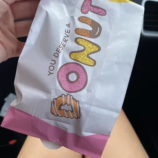 a person holding a bag of donuts