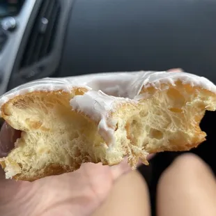 a hand holding a half eaten donut