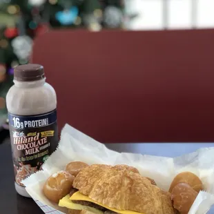 Sausage egg and cheese croissant, with half a dozen glazed donut holes, and a chocolate milk!