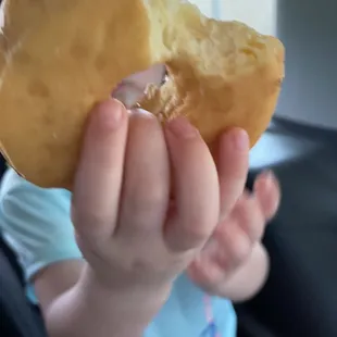 a little girl holding a half eaten donut