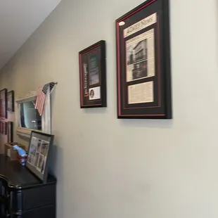 a kitchen with a refrigerator, microwave, and pictures on the wall