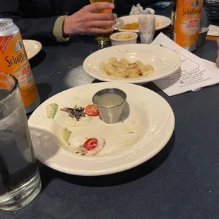 a half eaten plate of food and a glass of beer