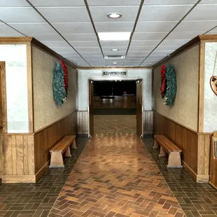 a hallway with benches and wreaths