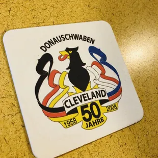 a black cat sitting on top of a coaster