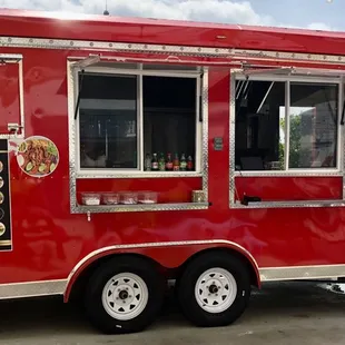 a red food truck parked in a parking lot