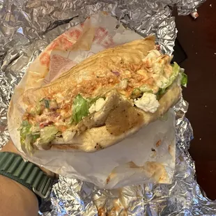 Pita with gyro, pickled vegetables, and both white and spicy sauces