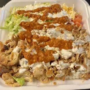 Chicken platter on rice with pepper sauce and garlic sauce .  Side of lettuce and tomatoes