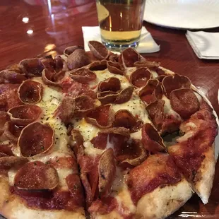 a pepperoni pizza with a glass of beer