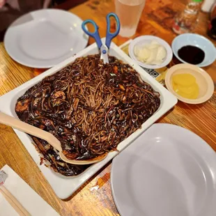 a plate of noodles and chopsticks on a table