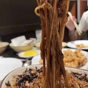 a plate of noodles with chopsticks