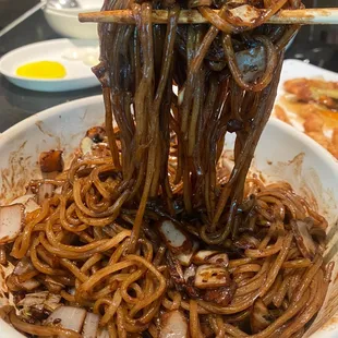 a bowl of noodles with chopsticks