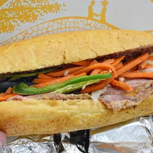 a person holding a sub sandwich