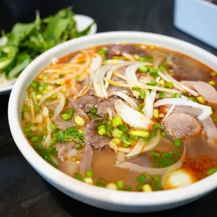 BN1. Bun Bo Hue Dac Biet Soup Noodle - House Special: Vietnamese ham, pig blood cubes, beef shank, pig trotter, tendon ($18.49).