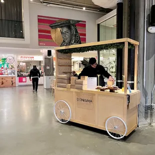 a man selling donuts from a cart