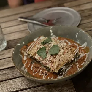 a plate of lasagna on a wooden table