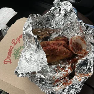 Breadsticks with exploded sauce due to melted plastic container.