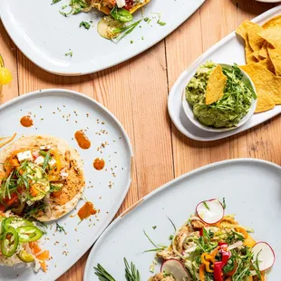 a variety of plates of food on a wooden table