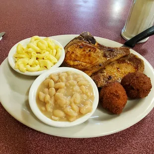 Pork chops, white beans, mac and cheese and hush puppies. All very good. Not over seasoned but not bland either.