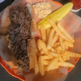 Philly cheesesteak with onions, fries and macaroni salad