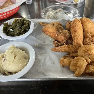 Chicken wings and shrimp platter with greens and mashed potatoes, no gravy.