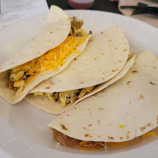two breakfast tacos on a paper plate