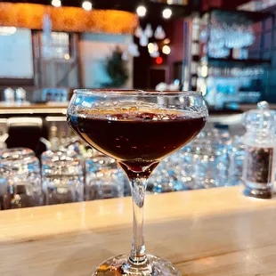 Black Manhattan cocktail. Rye whiskey, Averna Amaro, dash of Angostura bitters and orange bitters. Garnished with a Brandied cherry.