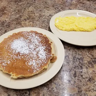 two plates of pancakes and eggs