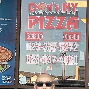 a man with sunglasses in front of a window