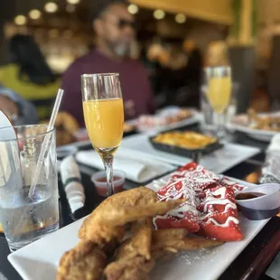 a plate of fried chicken and a glass of orange juice