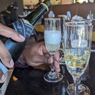 a person pouring a glass of wine