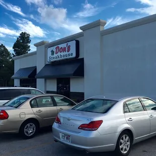 two cars parked in front of a restaurant