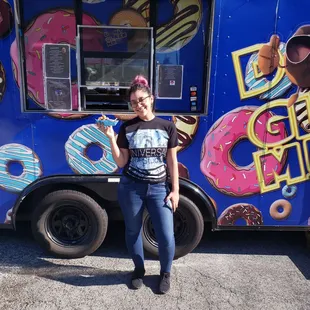 a woman standing in front of a food truck