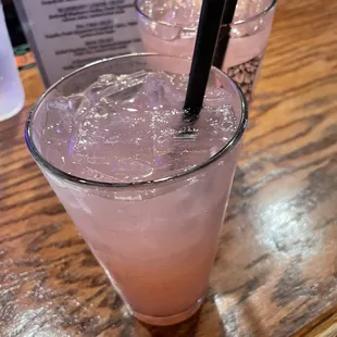 a pink drink with a black straw