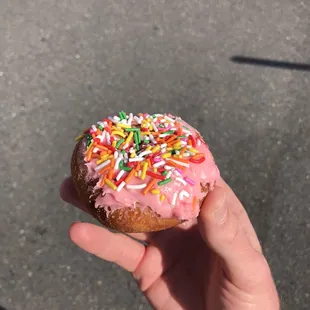 Cake donut with pink icing and sprinkles