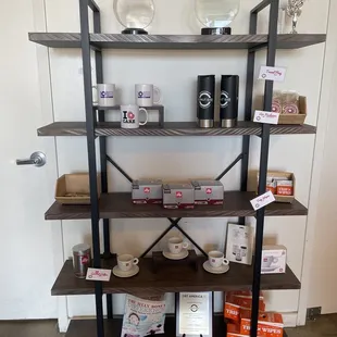 a shelf of coffee and coffee cups