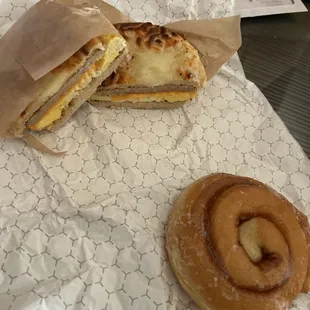 Sausage, egg, and cheese on garlic and cheese bagel. Cinnamon roll.