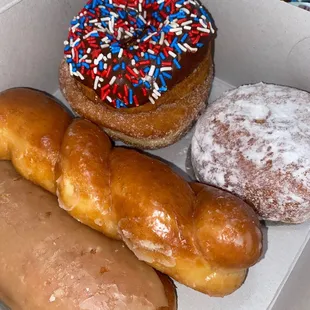 Maple bar, glaze twist, sugared donut, chocolate donut with sprinkles, and lemon jelly filled with powdered sugar.