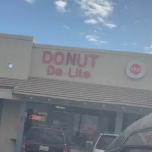 a car parked in front of a donut de - lite store