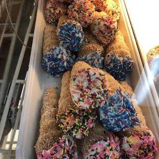 a tray of donuts with sprinkles