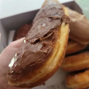 a hand holding a chocolate frosted donut