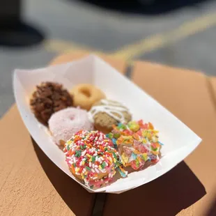 a tray of donuts with sprinkles