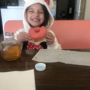 a little girl eating a donut