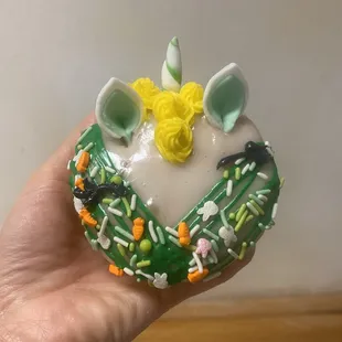 a hand holding a decorated donut