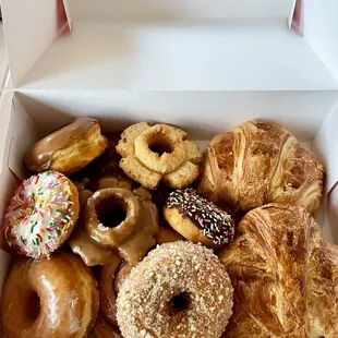 Assortment of donuts: Raised, Old Fashion, Cake, Cinnamon Roll, along with Plain Croissants